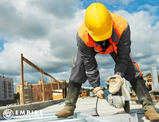 Builder cutting metal with an angle grinder on a construction site