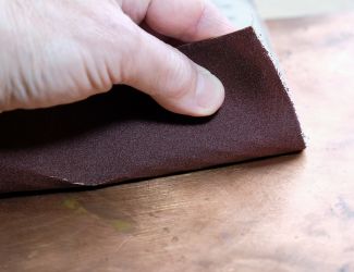 Sanding copper metal with sandpaper