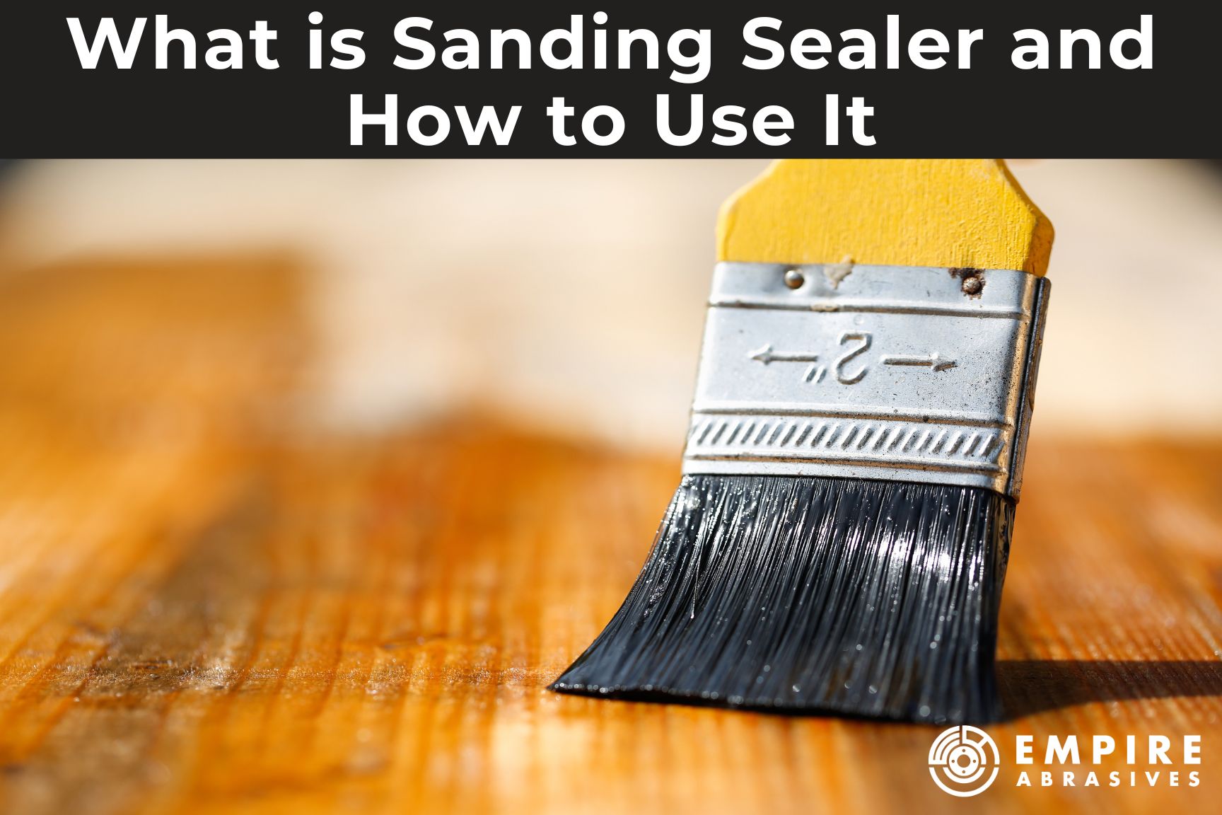 2" paintbrush applying sanding sealer to a wood surface. Blog post header image that says  "what is sanding sealer and how to use it" from Empire Abrasives